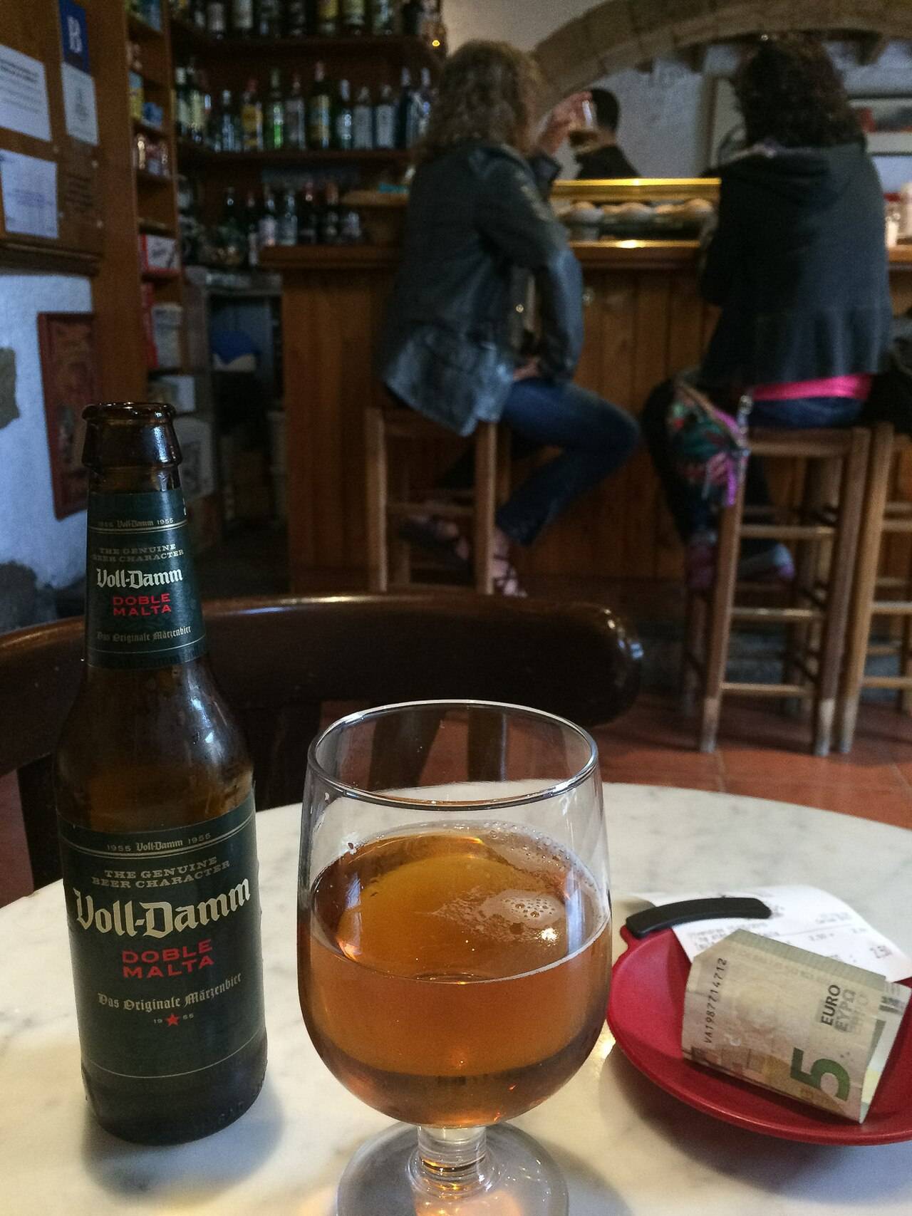 Interior de un bar de pueblo con clientes en la barra